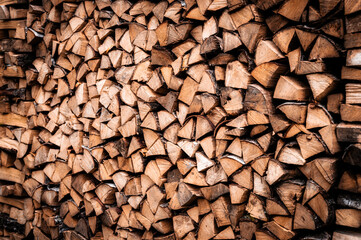 textured firewood background of chopped wood for kindling and heating the house. a woodpile with stacked firewood. the texture of the birch tree