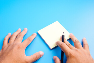 Hand and pencil write on the note book isolated navy blue background