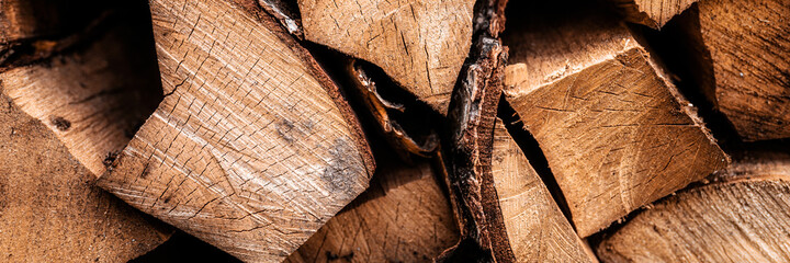 textured firewood background of chopped wood for kindling and heating the house. a woodpile with stacked firewood. the texture of the birch tree. banner