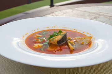 Traditional French cuisine. The famous dish of the fishermen of Marseilles Bouillabaisse soup with shrimps, mussels and fish in a white plate.