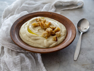 Soup of Jerusalem artichoke and croutons. Vegan cream soup in ceramic bowl. Close up. Copy space.