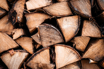Fototapeta premium textured firewood background of chopped wood for kindling and heating the house. a woodpile with stacked firewood. the texture of the birch tree