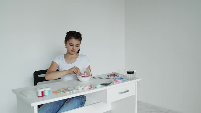 Girl edds beads step by step, young lady at the table