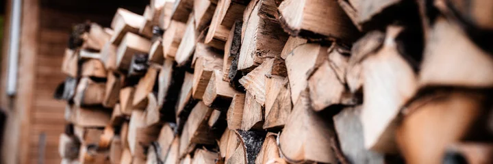  een houtstapel met oogst- en gestapeld brandhout van gehakt hout voor het aansteken en verwarmen van het huis. brandhout van de berkenboom. banier © Ksenia