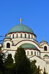 Fototapeta na wymiar The Temple of Saint Sava (Sveti Sava) - Serbian Orthodox church with clear blue sky in the background. Shot in day time during the golden hour.