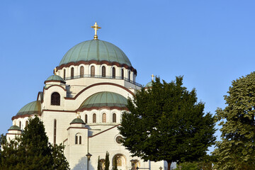 Fototapeta na wymiar The Temple of Saint Sava (Sveti Sava) - Serbian Orthodox church with clear blue sky in the background. Shot in day time during the golden hour.