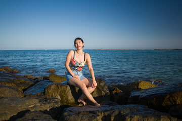 holidays lifestyle portrait of young Asian woman by the  sea -  happy and beautiful Korean girl  enjoying beach vacation trip relaxed and cheerful at beach rock cliff