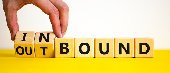 Inbound or outbound symbol. Businessman turns wooden cubes and changes the word 'outbound' to...