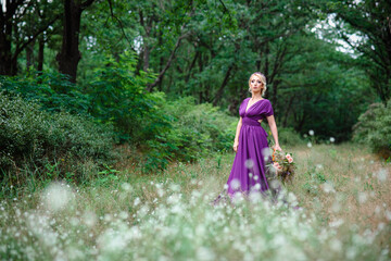 Girl model blonde in a lilac dress with a bouquet