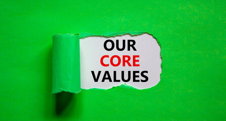 Our core values symbol. Words 'Our core values' appearing behind torn green paper. Beautiful green background. Business, our core values concept, copy space.