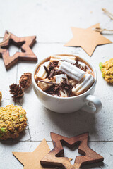 Christmas or New Year festive background. Hot chocolate or cocoa with marshmallow, cookies, christmas decorations, gray tiles background.