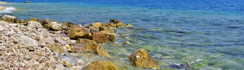 Stones on coast of azure sea. Focus on the center