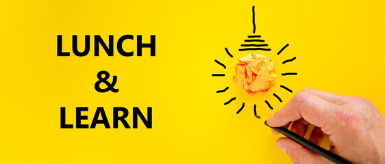 Lunch and learn symbol. Businessman writing words 'Lunch and learn', isolated on beautiful yellow background. Light bulb icon. Business, educational and lunch and learn concept. Copy space. - obrazy, fototapety, plakaty