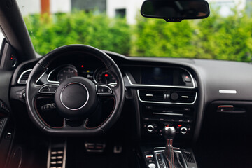 Fototapeta premium Expensive car interior with the steering wheel and multimedia dashboard
