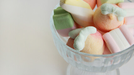 Marshmallow in a glass vase on a white background. Marshmallows in the form of different figures in a vase.Candys