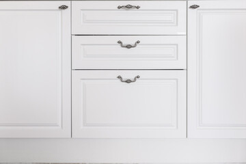 Fototapeta premium Front view of white wooden chest of drawers with metal long handles