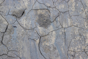 Close-up photo of the rough texture and gray color of the cracked earth in the area of ​​muddy volcanoes in Buzau, Romania; background photography