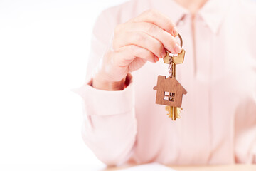 A woman holds the key to the house, the real estate agent, the place under the text