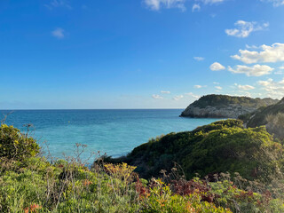 Fototapeta na wymiar Panorama with sea view. Landscape on the coast from cliffs. Turquoise-colored water with the horizon in the background.