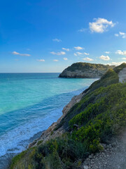 Panorama with sea view. Landscape on the coast from cliffs. Turquoise-colored water with the horizon in the background.