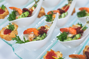 Catering table, beautifully decorated banquet with variety of with different food snacks and appetizers on corporate birthday party event or wedding celebration, seafood, canape, delicatessen setting
