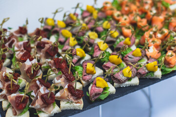 Catering table, beautifully decorated banquet with variety of with different food snacks and appetizers on corporate birthday party event or wedding celebration, seafood, canape, delicatessen setting