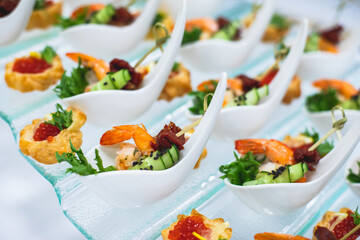 Catering table, beautifully decorated banquet with variety of with different food snacks and appetizers on corporate birthday party event or wedding celebration, seafood, canape, delicatessen setting