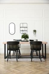 Stylish wooden dining table and chairs in room. Interior design