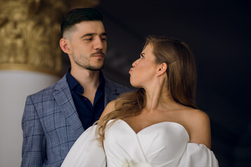 Portrait of a young couple in smart clothes. Stylish man and beautiful woman grimace and make a displeased face. Heterosexual couple grimacing and having fun