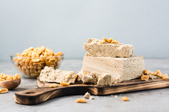 Pieces of sunflower and peanut halva on a cutting board on the table. Caloric oriental dessert