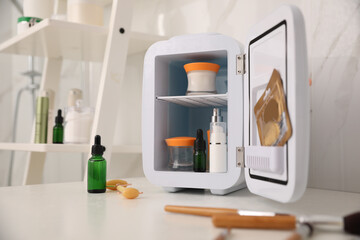 Mini refrigerator for cosmetic products on counter in bathroom