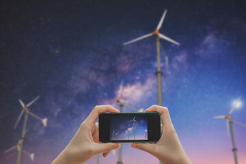 Taking photo on smart phone.Powerful and ecological energy concept with milky way.
