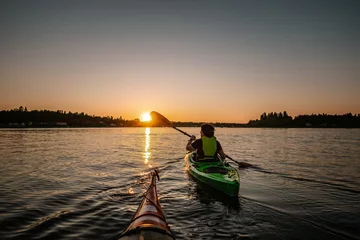 Foto op Canvas Girl kayaking in calm sea at midnight in Northern Sweden during light Summer nights. All day around Sun in polar regions. © Alexandre Patchine