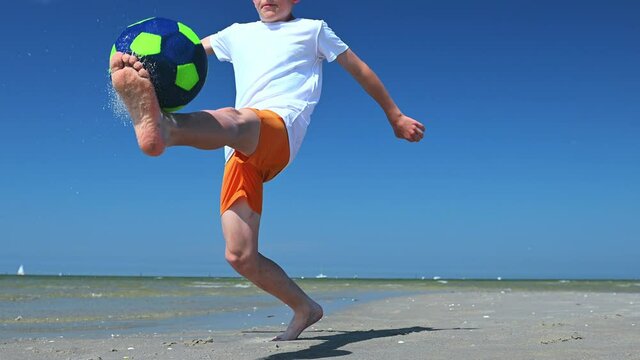 4K 60fps video of happy teen boy playing with ball on beach at sunny day