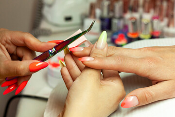 Nail stylist doing a manicure © Agata