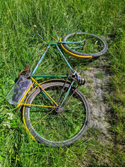 old classic bike abandoned on the grass during the daytime in summer.