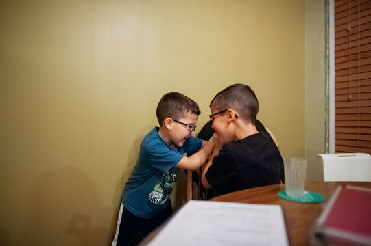 Two boys tickling each other. 