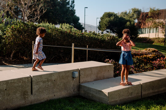 Young girls standing on landscape barrier
