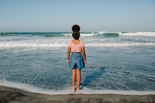 Black girl standing in seafoam