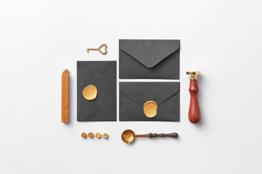 Flatlay of black envelopes, handle stamp and wax