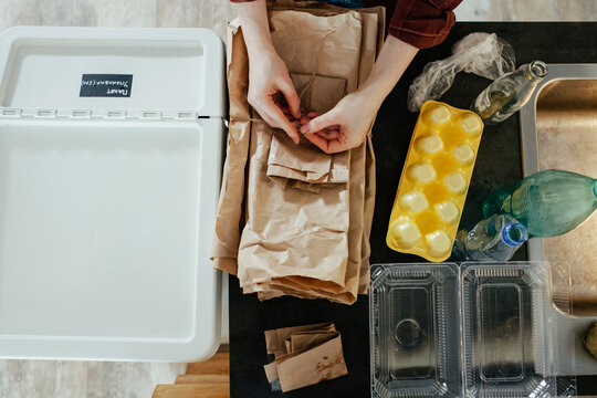 Unrecognizable housekeeper sorting garbage on counter