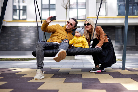 Happy family taking photo on playground 