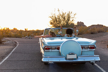 Two Best Girlfriends Girls on Desert Road trip driving down road in classic car 