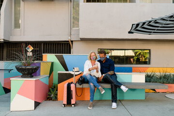 Masked and Traveling Couple Look at Phone