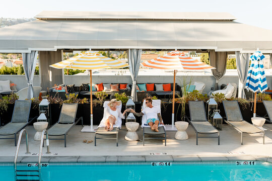 Mature Couple Relaxes on a Vacation Together by the Colorful Pool