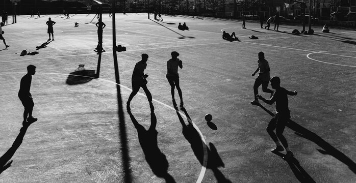 Fototapeta Black and white far view of urban soccer field with a group of people playing