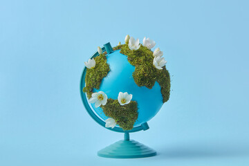 Globe with green moss and white flowers