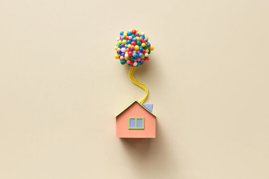Beige papercraft house model with balloons