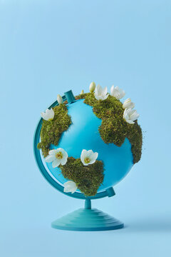 Earth globe with moss and flowers
