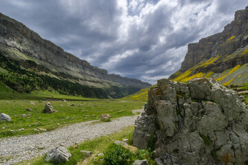 Hiking trail with rock under rain clouds in the spanish national park Ordesa y Monte Perdido, Pyrenees, Spain